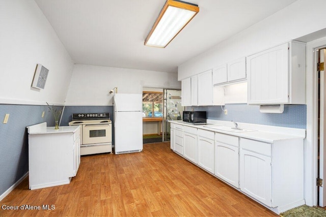 kitchen featuring light wood finished floors, a sink, white appliances, white cabinetry, and light countertops