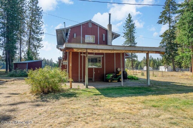 view of outdoor structure with fence and an attached carport