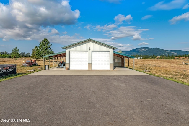 garage with a garage, a mountain view, and driveway