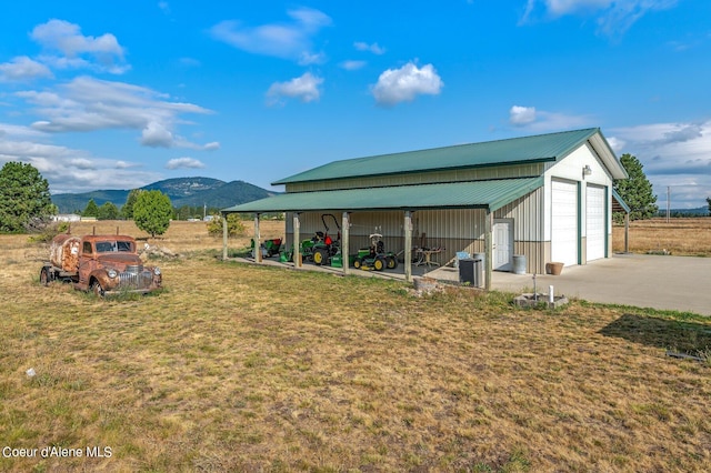 view of outbuilding featuring a mountain view, a yard, and a garage