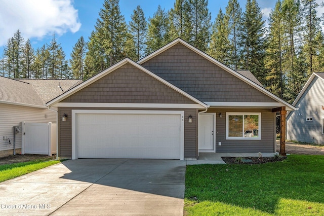 view of front facade with an attached garage, fence, a front lawn, and concrete driveway