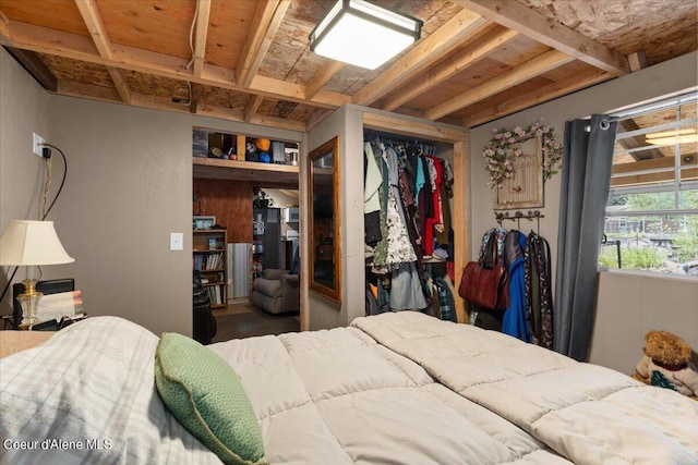 bedroom with beamed ceiling, wood ceiling, and a closet