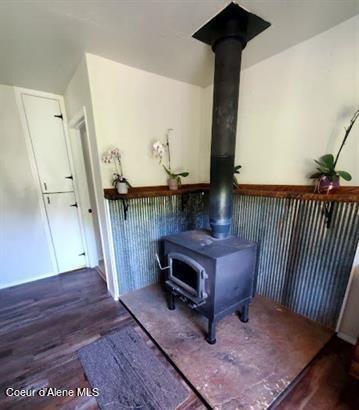 interior details with hardwood / wood-style floors and a wood stove