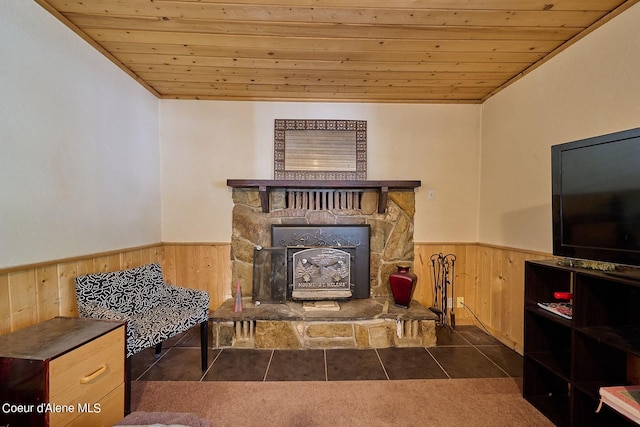 sitting room featuring a fireplace, dark tile patterned floors, and wooden ceiling