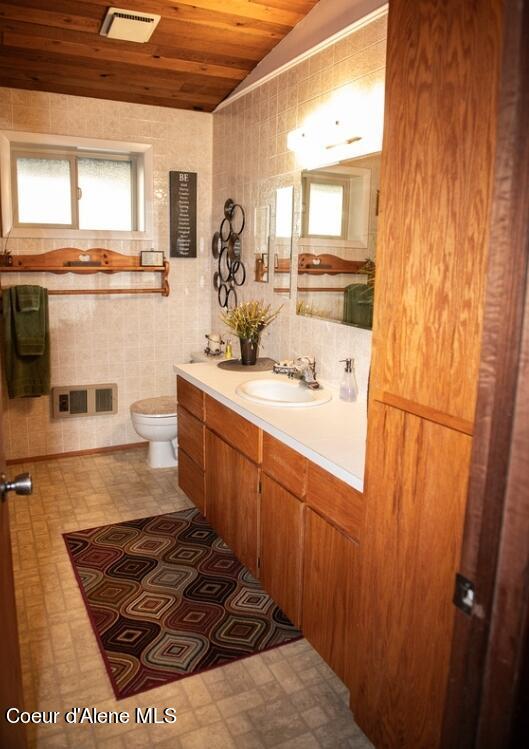 bathroom featuring vanity, tile walls, toilet, and wooden ceiling