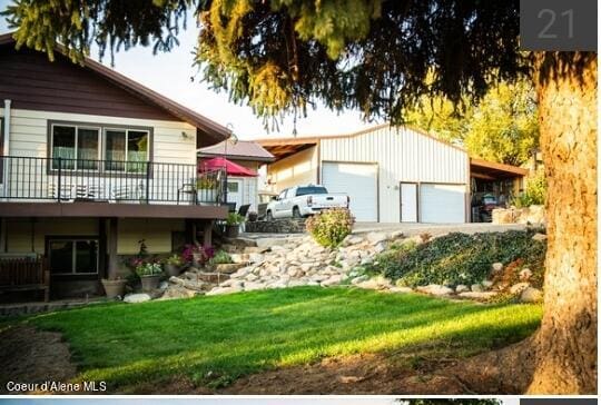 exterior space featuring a wooden deck, a yard, and a garage