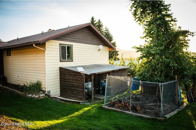 back house at dusk featuring a yard