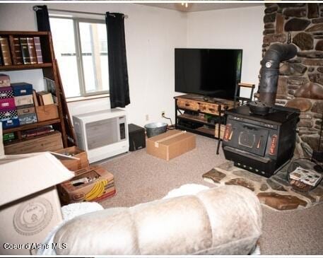 living room featuring carpet flooring and a wood stove