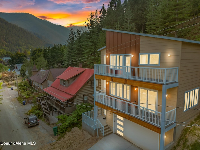 back house at dusk featuring a mountain view and a garage