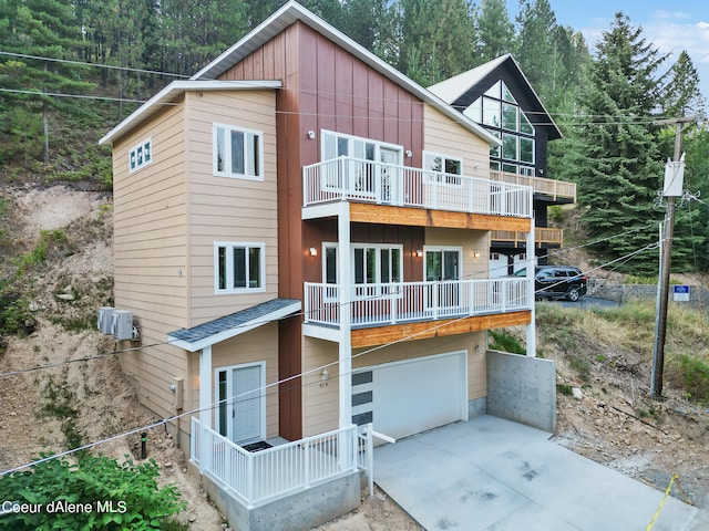 rear view of house featuring a garage and a balcony