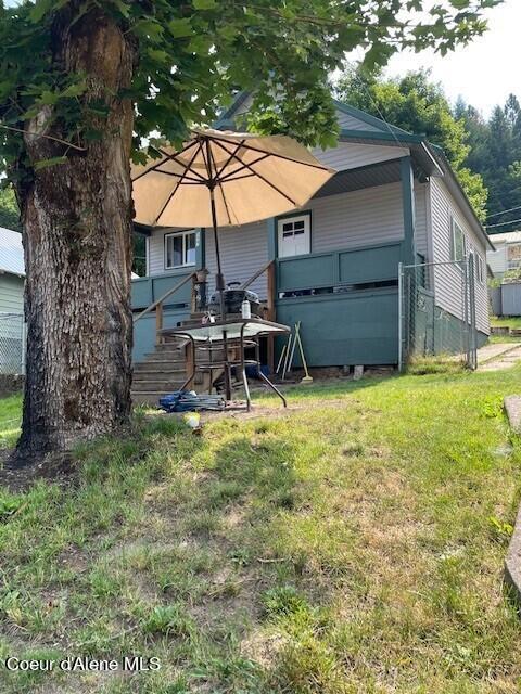 back of house featuring a wooden deck and a yard