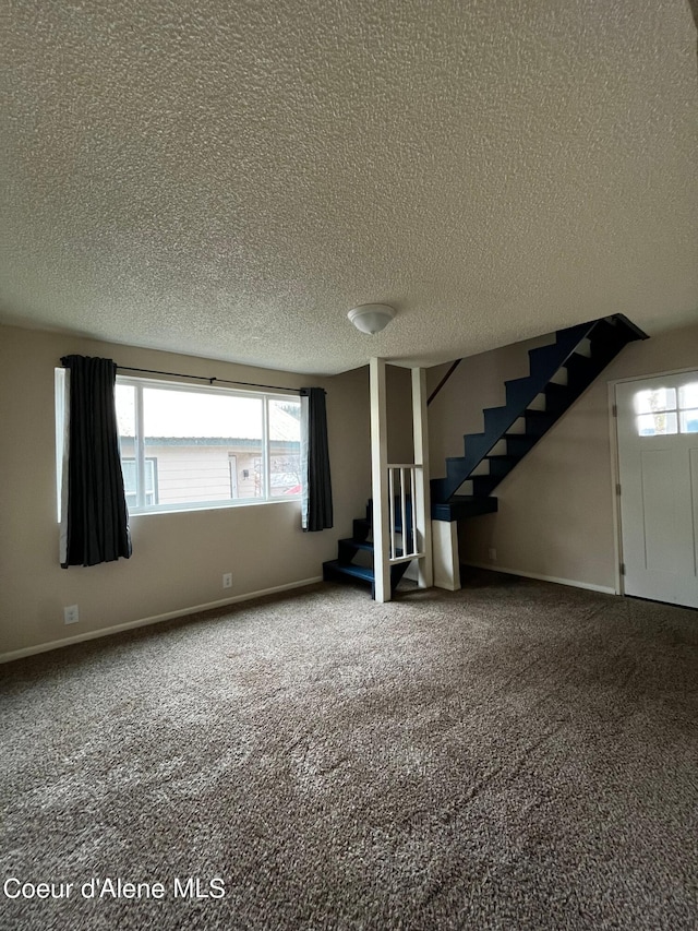 interior space with a textured ceiling and carpet flooring