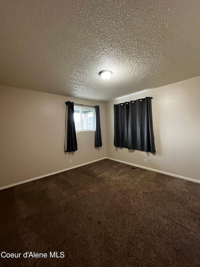 carpeted spare room with a textured ceiling