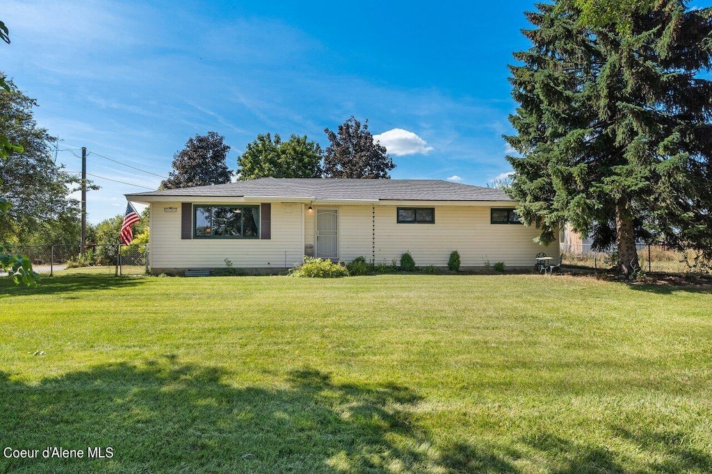 ranch-style home featuring a front yard and fence