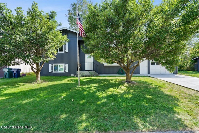 obstructed view of property featuring a front lawn and a garage