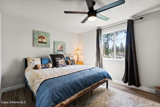 bedroom featuring hardwood / wood-style flooring, a textured ceiling, and ceiling fan