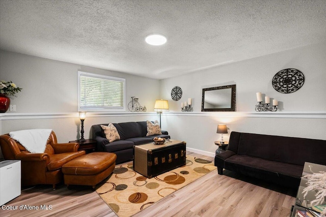 living room featuring a textured ceiling and light hardwood / wood-style floors