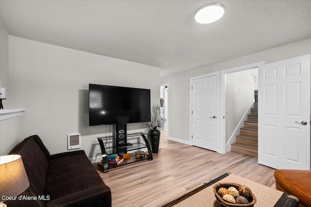 living room with light hardwood / wood-style flooring and a textured ceiling