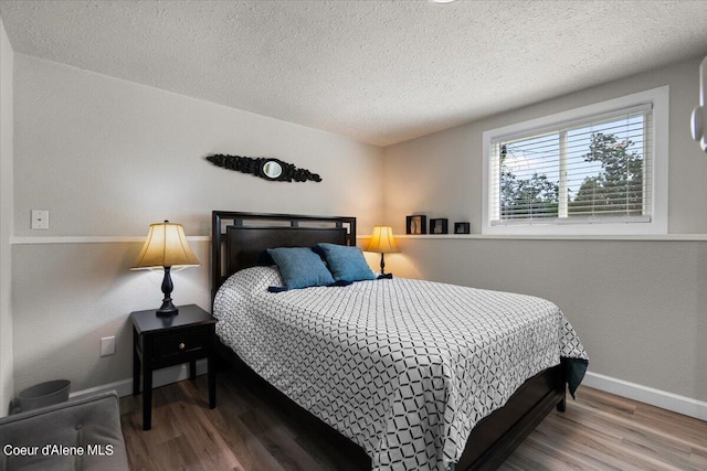 bedroom featuring hardwood / wood-style flooring and a textured ceiling