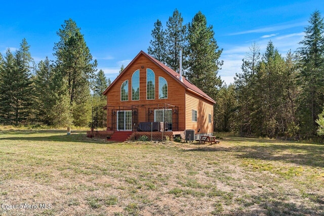 rear view of property with central AC and a lawn