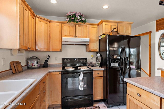 kitchen with under cabinet range hood, black appliances, light countertops, and a sink