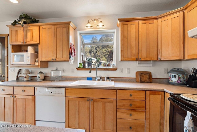 kitchen with white appliances, light countertops, and a sink