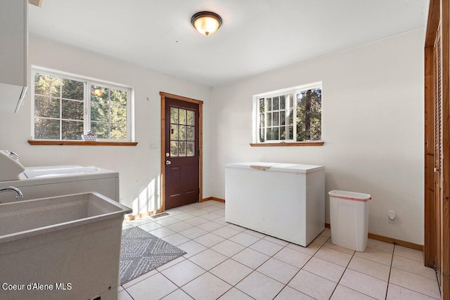 laundry room with sink, washing machine and clothes dryer, and light tile patterned flooring