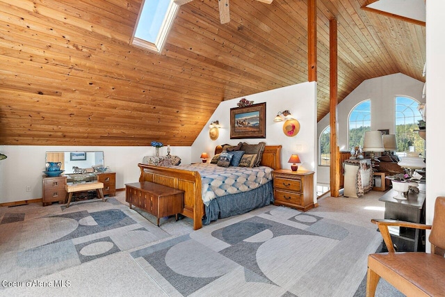 carpeted bedroom with high vaulted ceiling, wood ceiling, and a skylight