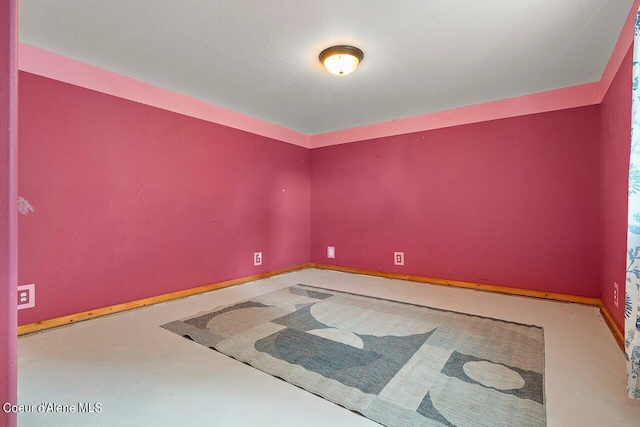 empty room featuring a textured ceiling and concrete floors