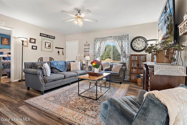 living room featuring ceiling fan and dark hardwood / wood-style flooring