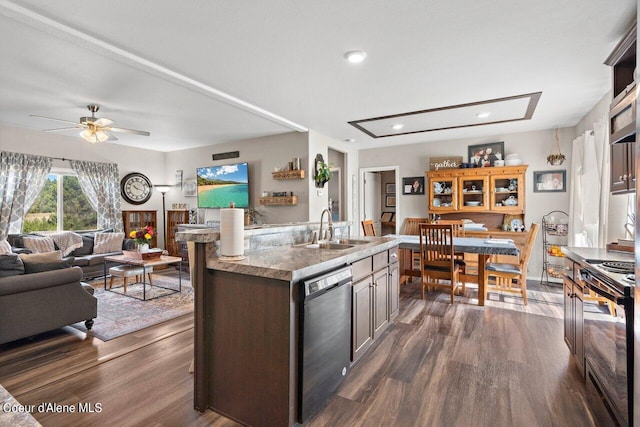 kitchen featuring ceiling fan, dishwasher, dark wood-type flooring, and a center island with sink