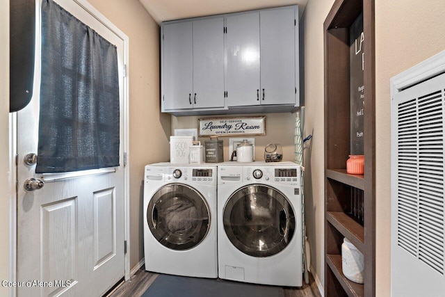 laundry room with washing machine and dryer, dark hardwood / wood-style floors, and cabinets