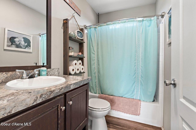 bathroom featuring wood finished floors, toilet, vanity, and shower / bathtub combination with curtain