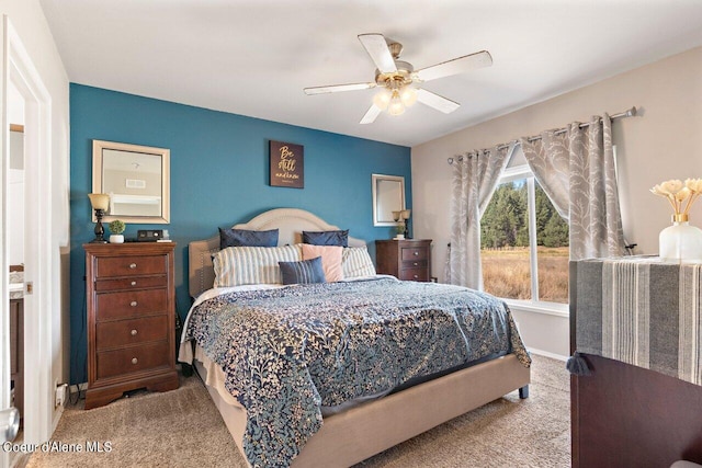 carpeted bedroom featuring baseboards and ceiling fan