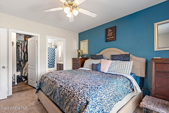 bedroom with a closet, ceiling fan, light hardwood / wood-style floors, and connected bathroom