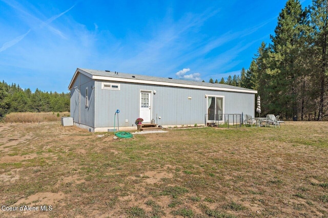 back of house featuring crawl space, a lawn, and entry steps