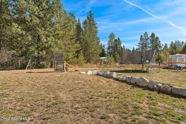 view of yard featuring a trampoline and a playground