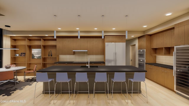 kitchen with dark countertops, beverage cooler, freestanding refrigerator, modern cabinets, and a sink