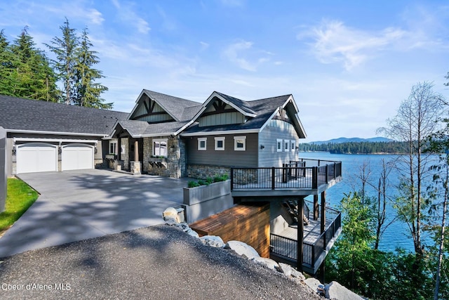 8491 N Mckinley Ln, Hayden, ID 83835 - view of front facade featuring driveway, stone siding, an attached garage, board and batten siding, and a shingled roof