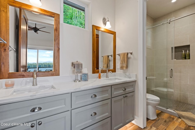 8491 N Mckinley Ln, Hayden, ID 83835 - full bath featuring a sink, a stall shower, a ceiling fan, double vanity, and wood finished floors