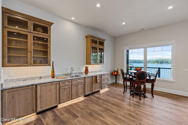 8491 N Mckinley Ln, Hayden, ID 83835 - kitchen featuring baseboards, recessed lighting, dark wood finished floors, glass insert cabinets, and light stone counters