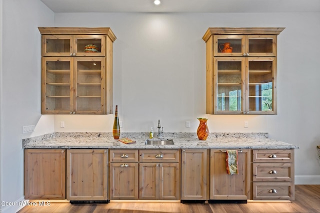 8491 N Mckinley Ln, Hayden, ID 83835 - kitchen with glass insert cabinets, light stone countertops, a sink, and wood finished floors