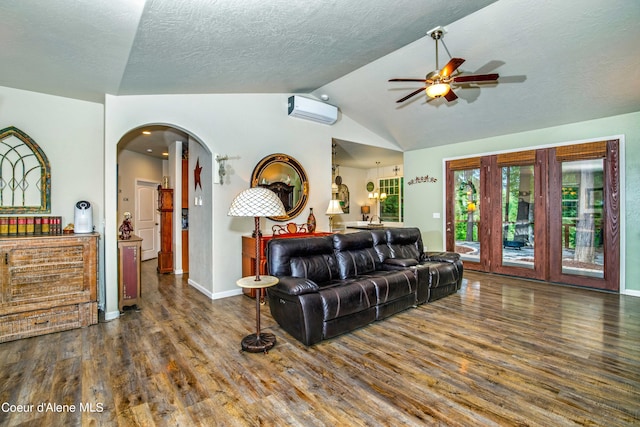 living room with a textured ceiling, vaulted ceiling, dark hardwood / wood-style floors, a wall mounted air conditioner, and ceiling fan