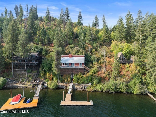 view of dock featuring a water view and a forest view