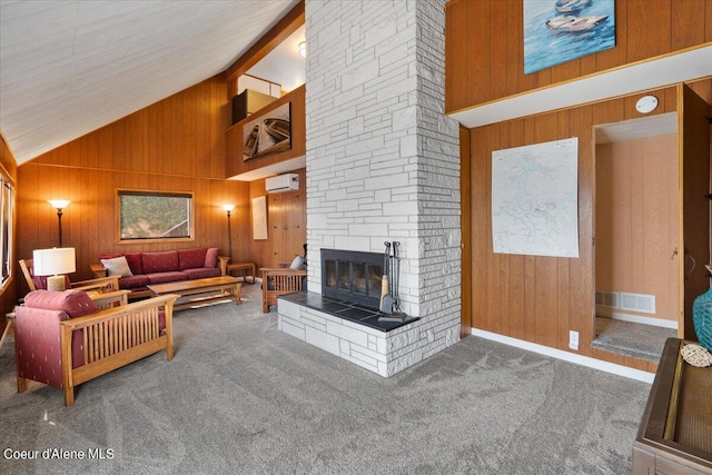 carpeted living room featuring wooden walls, a wall mounted air conditioner, a fireplace, high vaulted ceiling, and beam ceiling