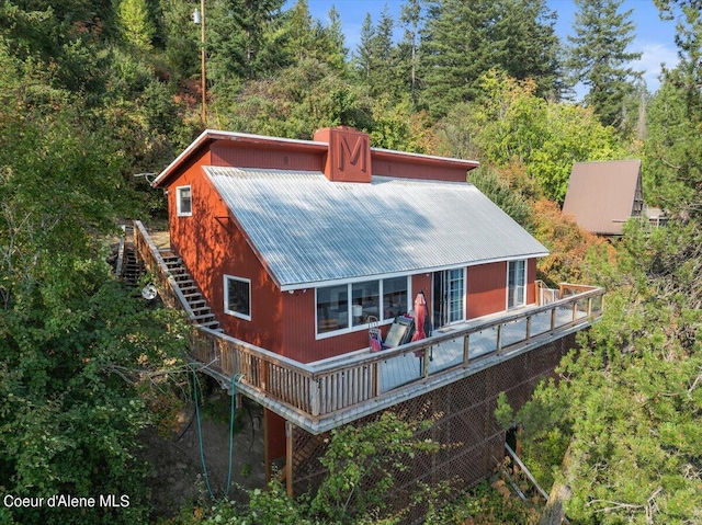 view of front of house featuring stairway and metal roof