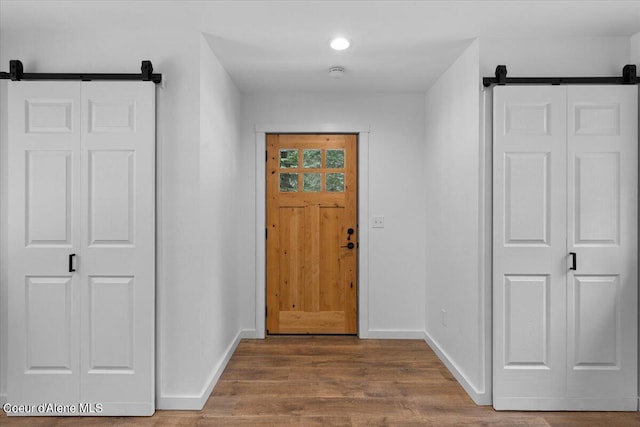 foyer entrance featuring a barn door and wood-type flooring