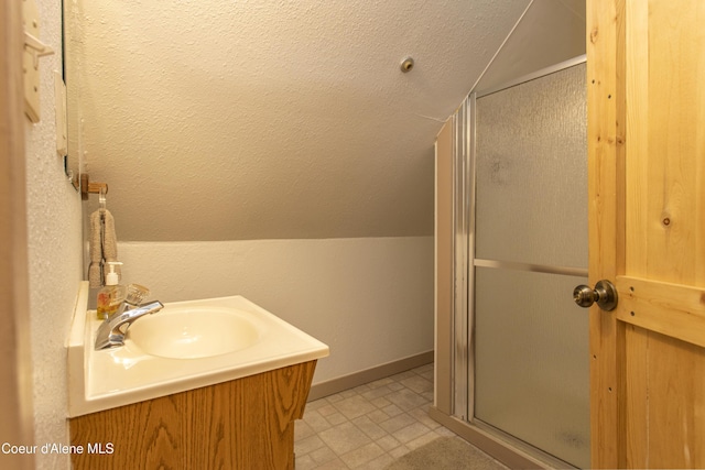 bathroom with vaulted ceiling, a shower with door, and sink