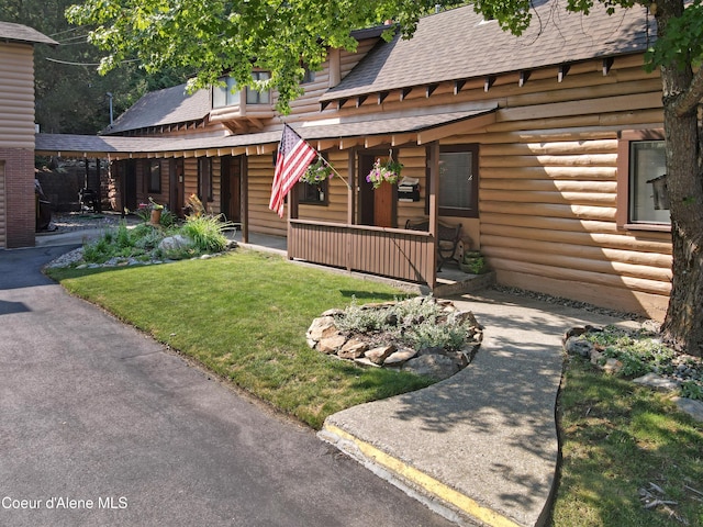 log home with a front yard and covered porch