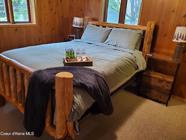 bedroom with carpet flooring and wooden walls